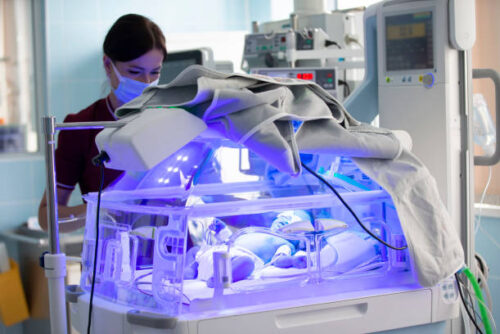 A newborn baby is treated for jaundice under ultraviolet light in an incubator. Department of neonatal resuscitation, intensive care unit for premature newborns.