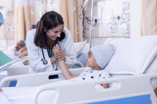 Female doctor examining little girl patient at hospital.