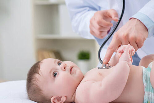 So beautiful world. Professional pediatrician holding stethoscope and examining infant  while being enticed in work
